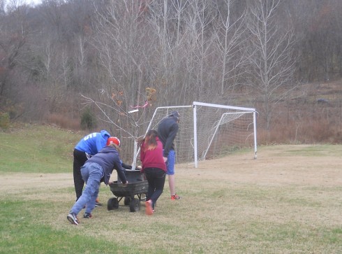 Students ferry the new apple tree up to the orchard.