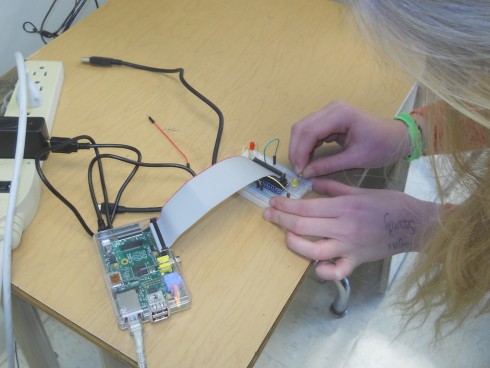 Student wires the breadboard attached to a Raspberry Pi.