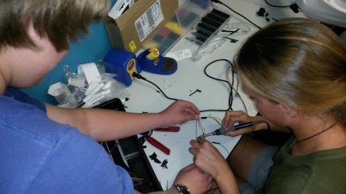 Students learn to solder. 