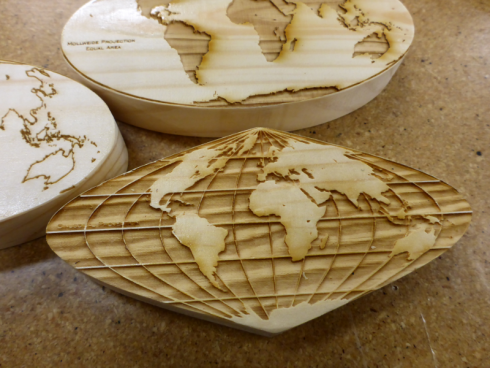 Laser-etched map projections on wood.