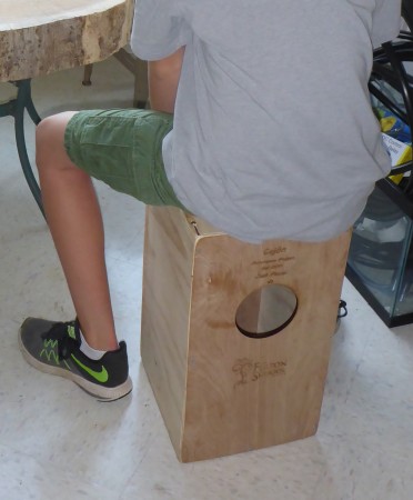 Student sits atop a Cajón.