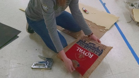 Upholstering a small stool.